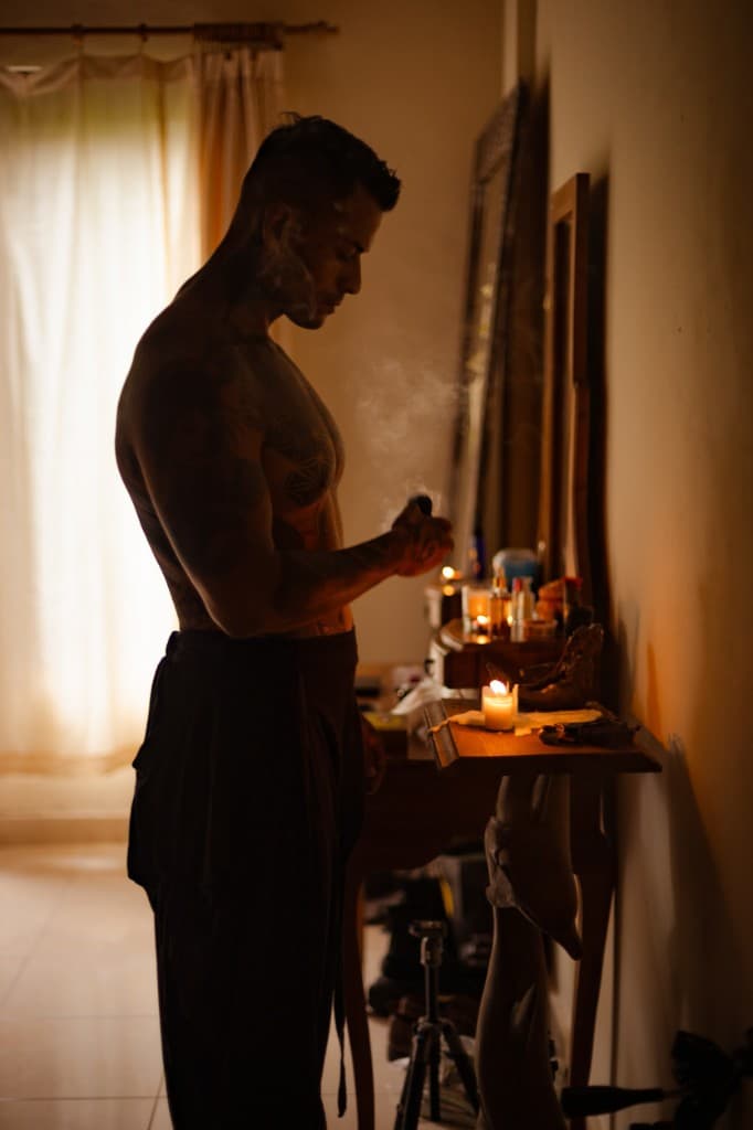 Octavio in a quiet, candlelit space, holding space for embodied practice.